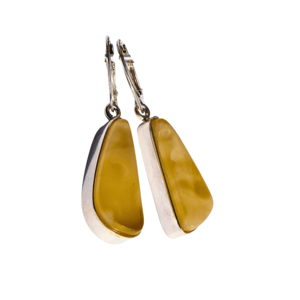 Elegant sterling silver drop earrings featuring smooth, honey-yellow Baltic amber. The teardrop-shaped amber stones display mesmerizing natural swirls, set in a sleek silver frame with secure lever-back clasps. A timeless and sophisticated design, perfect for any occasion.