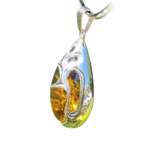 The teardrop-shaped amber pendant, set in silver with a swirling design that highlights the amber's warm tones, is a legendary masterpiece of artisan craftsmanship—a collector’s dream.