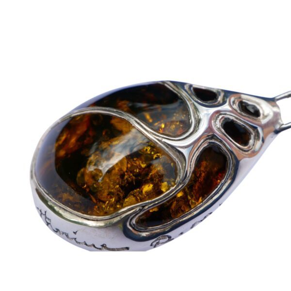 The "Legendary Masterpiece of Artisan Craftsmanship" is a collector's dream, showcasing an amber pendant in a detailed silver setting with swirling, abstract designs that enhance the gemstone's allure.