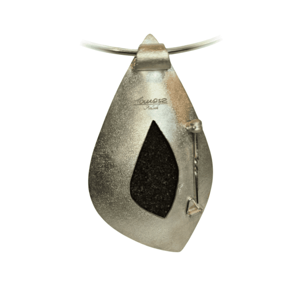 a silver pendant with a black stone inside