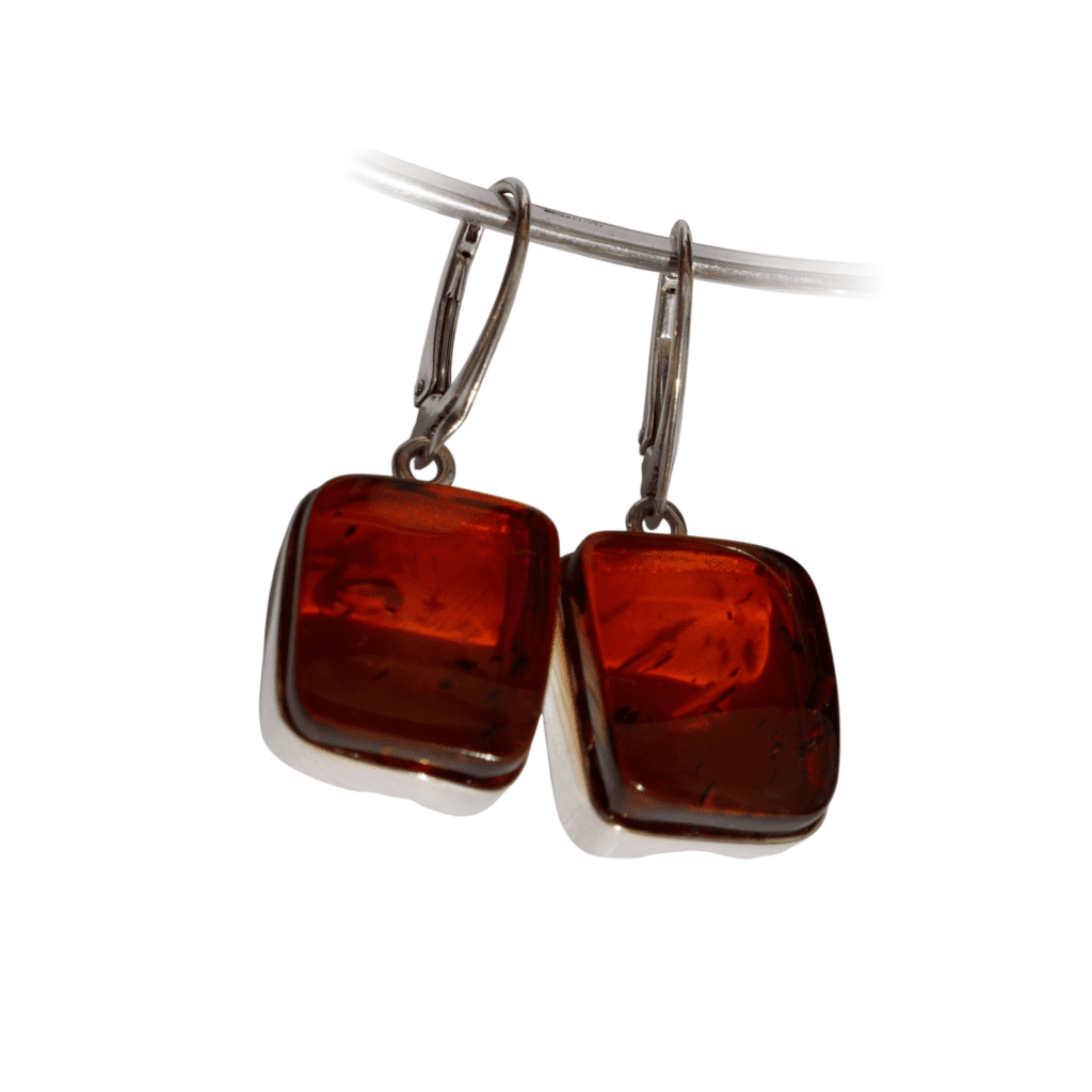 a pair of earrings with a red square shape