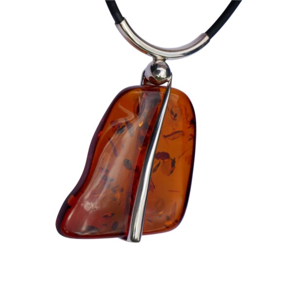 The elegant Cognac Amber and Silver Twist Set features a stunning amber pendant with dark inclusions, gracefully hanging on a black cord.