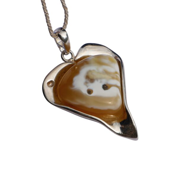 The ETERNAL HEART is a heart-shaped pendant featuring rare Baltic amber in amber brown and white hues, set in a silver frame, and hanging on a chain.