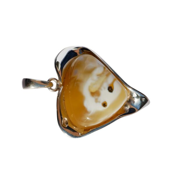 ETERNAL HEART: RARE BALTIC AMBER & SILVER PENDANT, showcasing a polished brown and white amber stone in a heart shape, elegantly set in a silver frame.