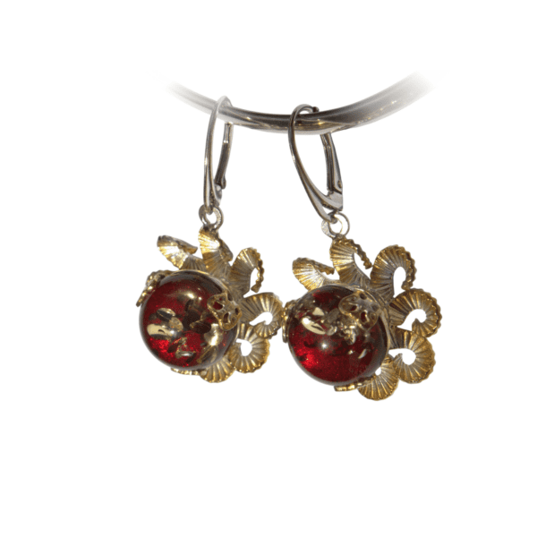 a pair of earrings with red glass balls