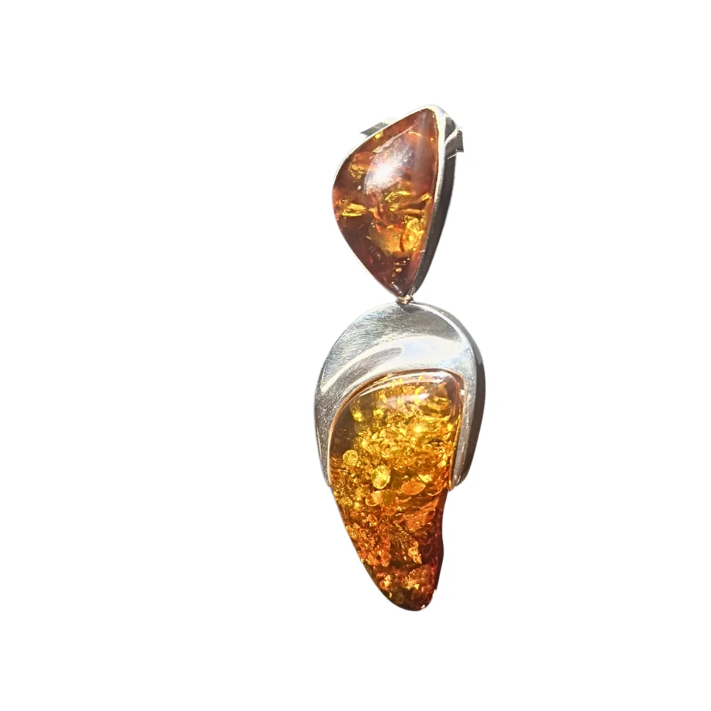 Cognac amber pendant with intricate inclusions, set in a solid sterling silver sculptural frame. The back features raw, unpolished amber for natural authenticity.