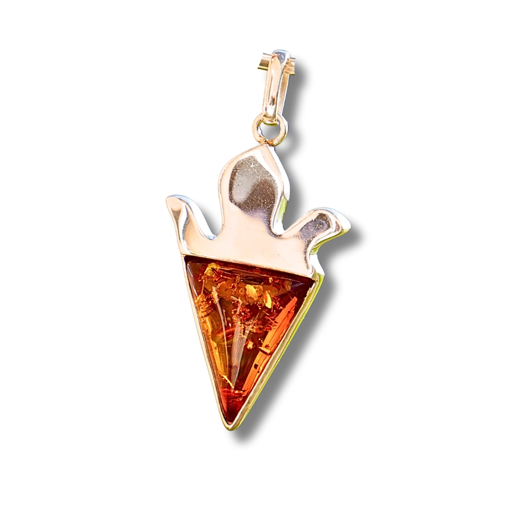 Close-up front view of a cognac amber pendant with a triangular cut, set in polished sterling silver. The amber's golden inclusions glow naturally