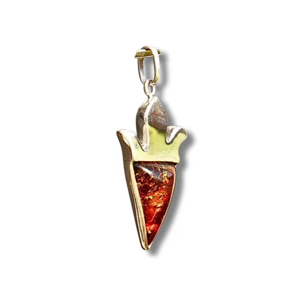 A side-angle view of a handcrafted cognac amber pendant in sterling silver, revealing its depth and rich golden inclusions.